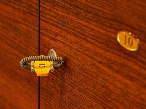 a padlock on a wooden door with a button at Hokuriku Fukui Awara Onsen Mimatsu in Awara