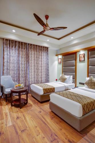 a bedroom with three beds and a ceiling fan at Hotel The Pearl, City Center - Traveler's Choice Award Winner for 2025 in New Delhi