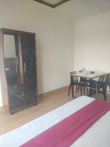 a room with a bed and a table with chairs at Chill mount vagamon in Vagamon