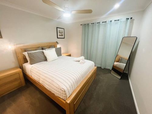 a bedroom with a bed and a mirror in it at Esperance Getaway in Esperance