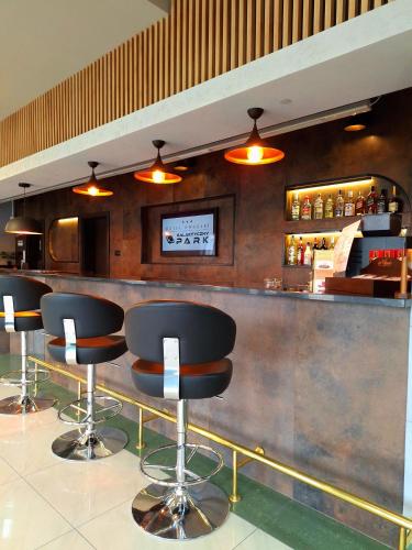 a bar with black stools in a restaurant at Hotel Dworski Galaktyczny Park in Szczecin