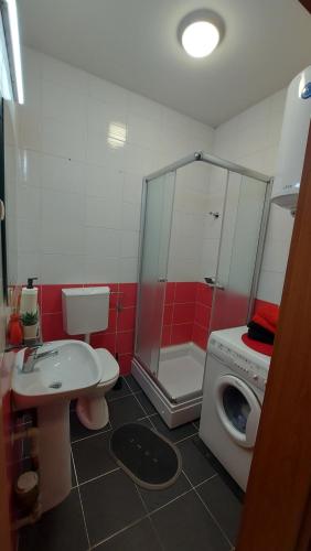a bathroom with a shower toilet and a washing machine at Apartment 4 You in Skopje