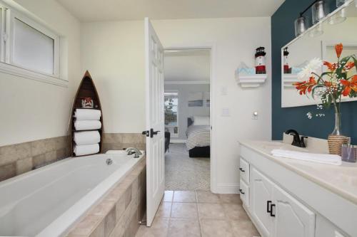 un bagno con vasca, lavandino e vasca da bagno di Fairway Harbor View by AvantStay Outdoor Oasis a Freeland