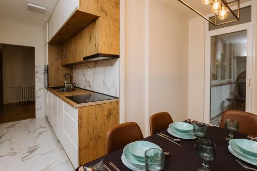 ベオグラードにあるBright, Newly Renovated Condo Near Danube Riverのテーブルとキッチンのあるダイニングルーム