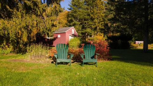 two green chairs and a table in the grass at Whitney by AvantStay Private Berkshires Estate in Sheffield