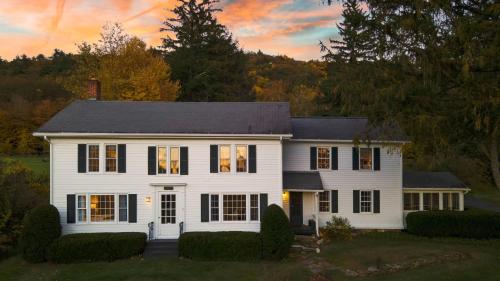 a white house with a black roof at Whitney by AvantStay Private Berkshires Estate in Sheffield