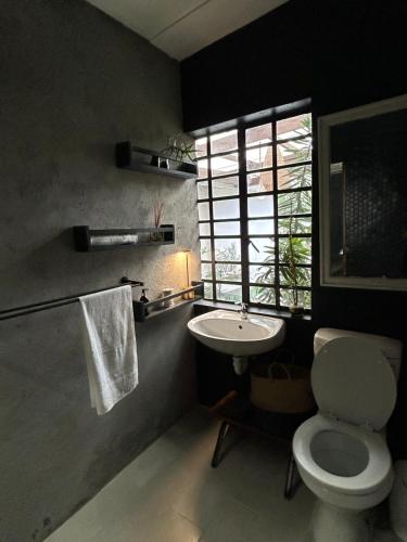 a bathroom with a toilet and a sink and a window at La Casetta, Garden Retreat in Cape Town