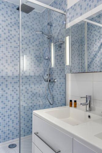 une salle de bain avec un lavabo et une douche avec du carrelage bleu dans l'établissement 3 Rooms with Sea View Terraces in Peace, à Saint-Tropez