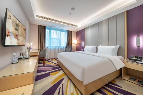 a hotel room with a large bed and a desk at Lavande Hotel Xi'an Bell Tower Muslim Street North Street Subway in Xi'an