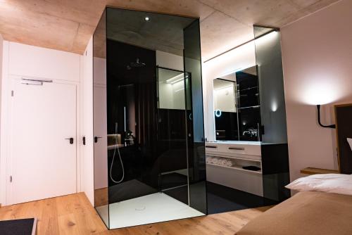a glass shower in a room with a bed at Villa Boutique Hotel in Straubing
