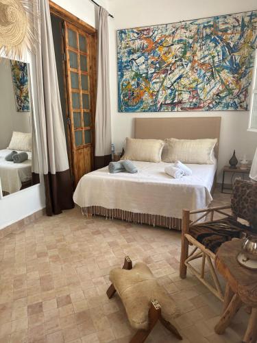 a bedroom with a bed and a large painting on the wall at Dar Inès in Tangier