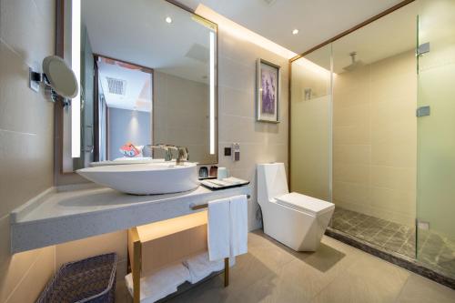 a bathroom with a sink and a toilet and a mirror at Lavande Hotel Xi'an Bell Tower Muslim Street North Street Subway in Xi'an