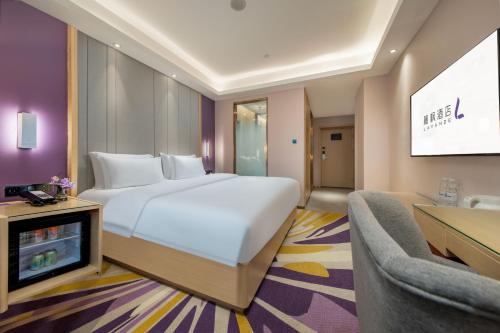 a bedroom with a large white bed and a tv at Lavande Hotel Xi'an Bell Tower Muslim Street North Street Subway in Xi'an