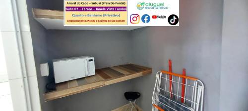 a microwave sitting on a wooden shelf in a room at Arraial do Cabo – Subuai Village - Aluguel Econômico in Arraial do Cabo