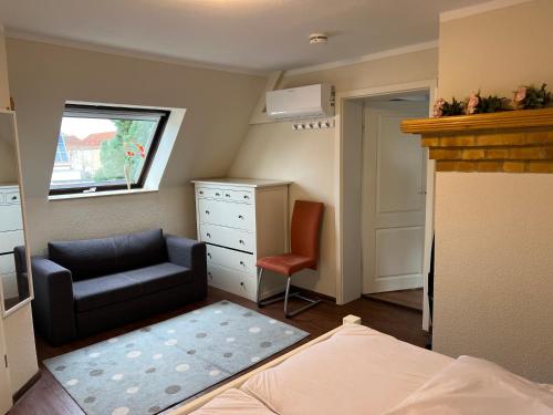 a bedroom with a chair a dresser and a bed at Wunderschöne Ferienwohnung in Brandenburg an der Havel