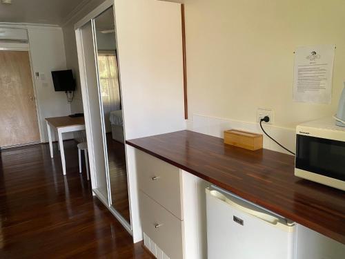 a kitchen with a counter top and a microwave at Paradise Motel Busselton in Busselton