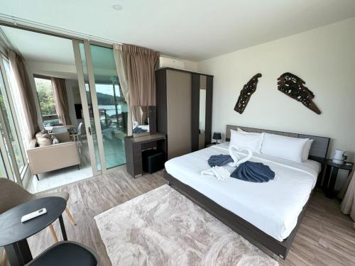 Un dormitorio con una cama con sábanas y almohadas blancas. en Apartment with panoramic views at Oceana by Lofty, en Kamala Beach