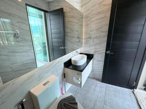 Un baño con inodoro, lavabo y espejo. en Apartment with panoramic views at Oceana by Lofty, en Kamala Beach