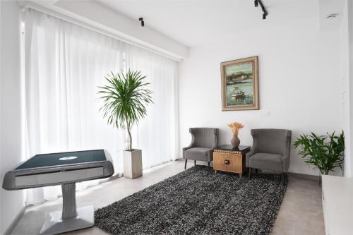 a living room with two chairs and a piano at Serene Vale Inn Railway station free pick-up by 2 nights English and Spanish reception available in Guilin