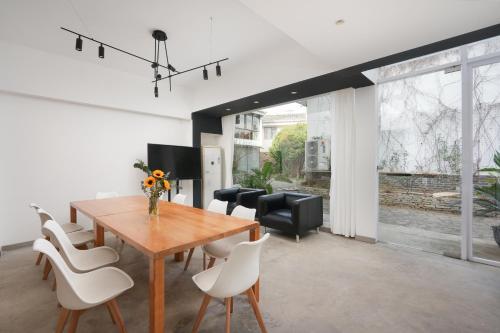 a dining room with a wooden table and white chairs at Serene Vale Inn Railway station free pick-up by 2 nights English and Spanish reception available in Guilin