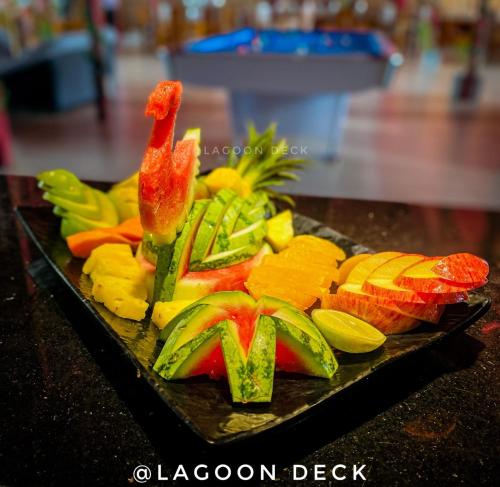 a plate of fruit and vegetables on a table at New Saniro Lagoon Deck in Katunayaka