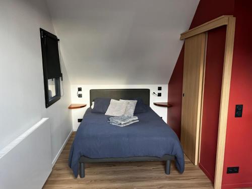 a bedroom with a bed and a red and white wall at Ty Nid d'Amour Ty Matlo in Névez