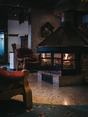 a fireplace in the middle of a living room at Sporthotel Royer in Schladming