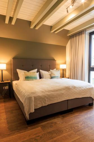 a bedroom with a large bed with two lamps at Goldregen - Domizil am Ostseewald in Zingst