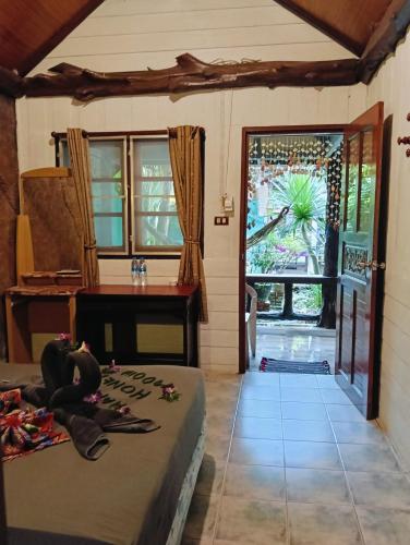 a room with a bed and a table and a window at P P Garden Home Bungalow in Phi Phi Don