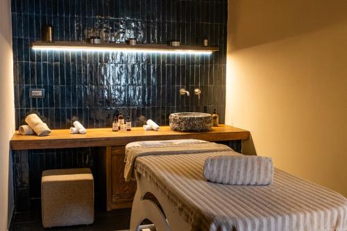 a bathroom with a sink and a bench in front of it at Masseria Donna Menga - The Leading Hotels of the World in Torre Lapillo