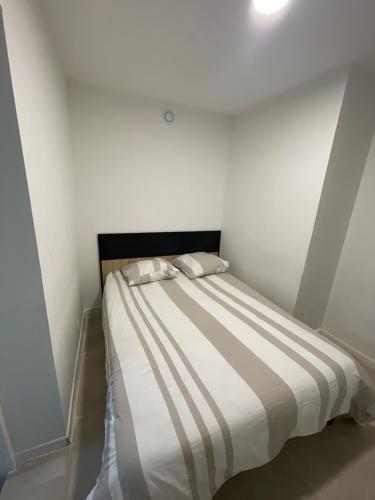 a bed with two pillows on it in a room at maisonnette de vacances in Annet-sur-Marne