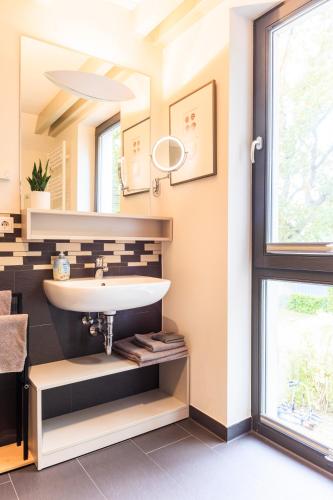 a bathroom with a sink and a window at Goldregen - Domizil am Ostseewald in Zingst