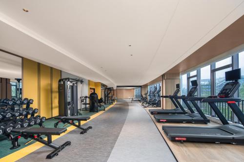 a gym with a row of treadmills and machines at Holiday Inn Guiyang Airport by IHG in Guiyang