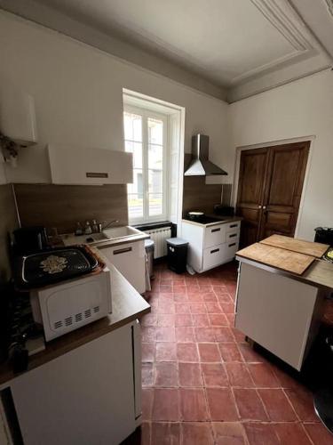 - une cuisine avec des appareils blancs et du carrelage rouge dans l'établissement La villa de Jacques et Mitzi, à Villeneuve-lès-Béziers