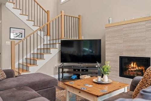a living room with a television and a fireplace at Lakeside Serenity by AvantStay Lakefront Newly Built Deck w Views in White Haven