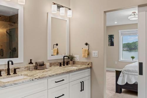 a bathroom with two sinks and a large mirror at Lakeside Serenity by AvantStay Lakefront Newly Built Deck w Views in White Haven