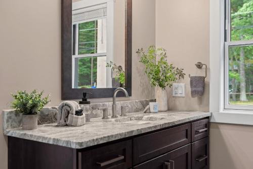 a bathroom with a sink and a mirror at Lakeside Serenity by AvantStay Lakefront Newly Built Deck w Views in White Haven