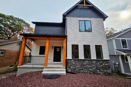 a white house with a black roof and orange columns at Lakeside Serenity by AvantStay Lakefront Newly Built Deck w Views in White Haven