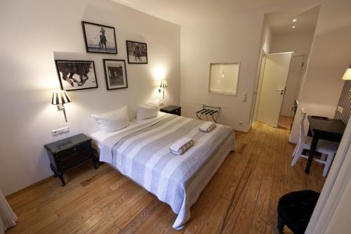 a bedroom with a bed with white sheets and a desk at Villa Delange in Landau in der Pfalz