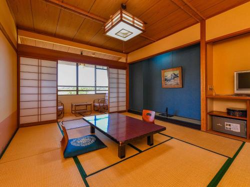 a living room with a table in a room at Hokuriku Fukui Awara Onsen Mimatsu in Awara