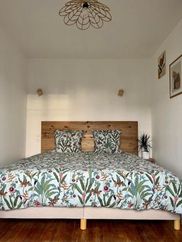 une chambre avec un grand lit avec une tête de lit en bois dans l'établissement Appartement centre-ville 2 personnes, à Troyes