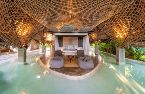 a resort with a pool and a table and chairs at Bamboo Zanzibar in Jambiani