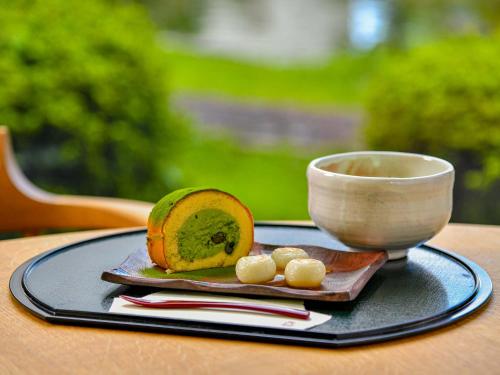 a plate with a bowl and a piece of fruit on a table at Hokuriku Fukui Awara Onsen Mimatsu in Awara