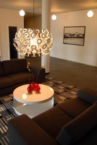 a living room with a couch and a chandelier at Hotel Nørherredhus in Nordborg