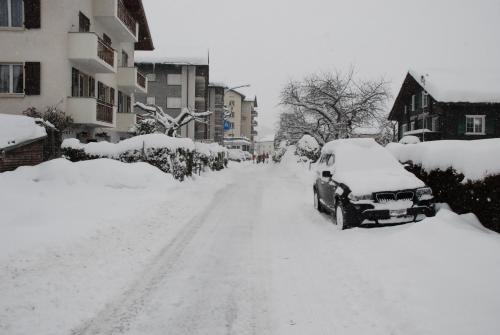 a snow covered street with a car covered in snow at Haus Montanara in Unterbäch