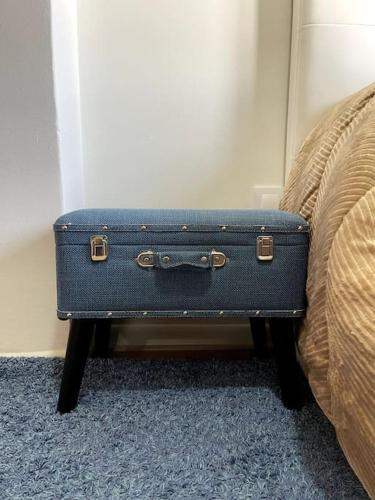 a blue suitcase sitting on a stool next to a bed at Apartamento 3 habitaciones en Plaza de España 6PAX in Vigo