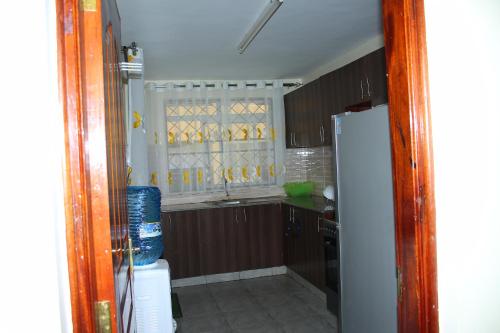 a kitchen with a window and a refrigerator at Ecostay 3bedroom ground floor in Kisumu