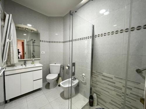 a bathroom with a toilet and a glass shower at Apartamento 3 habitaciones en Plaza de España 6PAX in Vigo