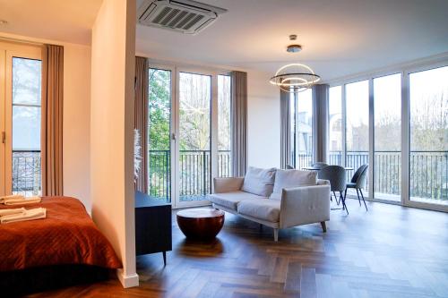 a living room with a bed and a couch at Seaside Garden by Baltic Home in Świnoujście