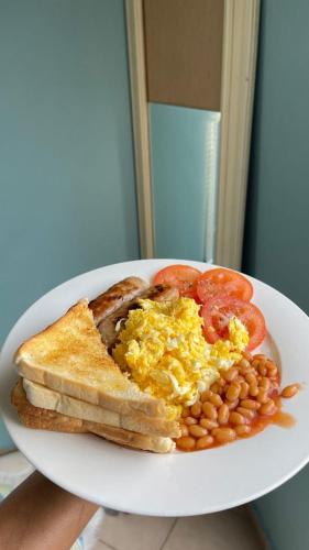 a plate of breakfast food with eggs beans and toast at Gono Compound in Harare